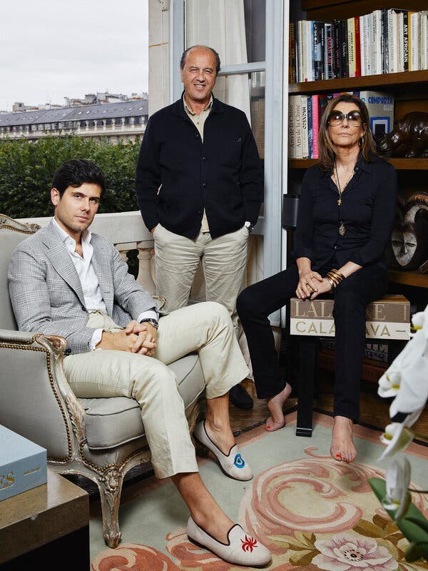 Alexandre Assouline, Prosper Assouline and Martine Assouline, beside an open window with a bookcase behind them.