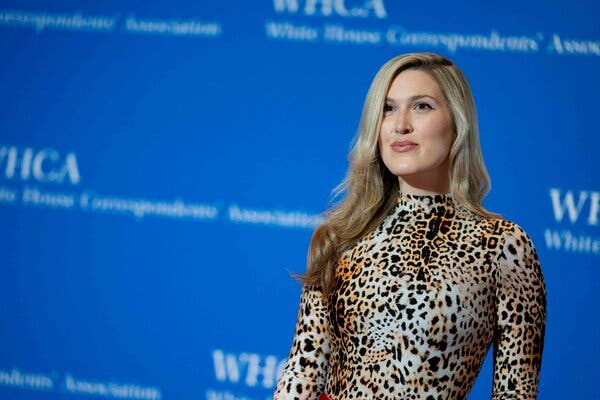 Olivia Nuzzi wearing an animal print top against a blue backdrop.