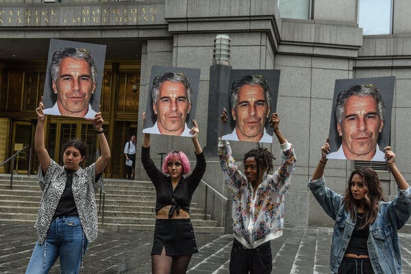 People standing in front of a courthouse holding up photographs of Jeffrey Epstein.