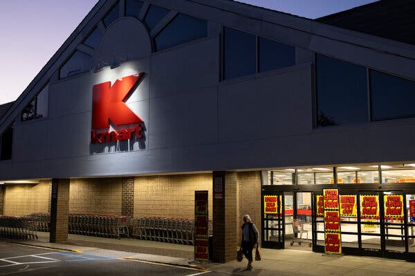 A Kmart in twilight, with “Store Closing Sale!” signs covering the entrance.