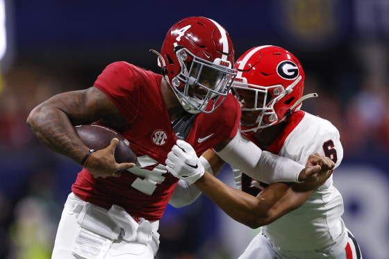 Jalen Milroe #4 of the Alabama Crimson Tide is pursued by Daylen Everette #6 of the Georgia Bulldogs during the first quarter in the SEC Championship at Mercedes-Benz Stadium on December 2, 2023 in Atlanta, Georgia.