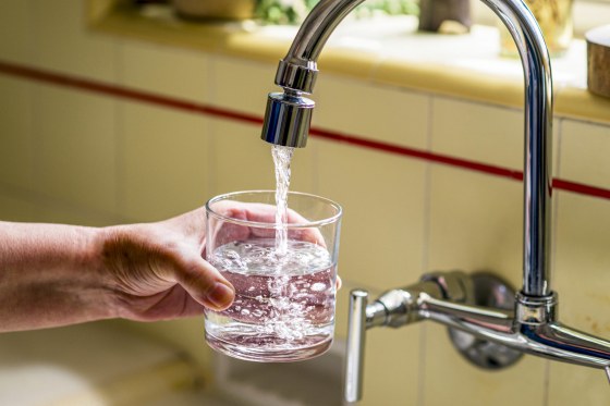 Pouring a glass of water from a kitchen faucet.