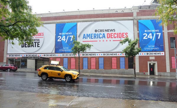 A large sign, in red, white and blue, on the CBS building in Manhattan advertising the station's vice-presidential debate.