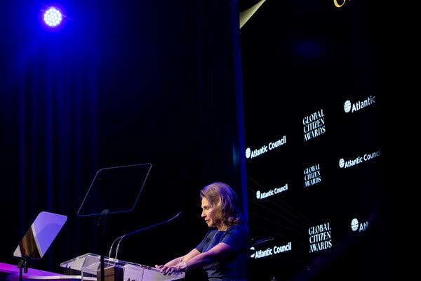 Shari Redstone seen in profile at a lectern with a blue light overhead.