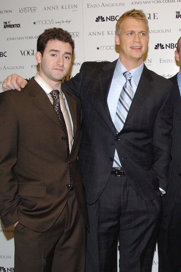 Andy Litinsky, in a brown suit, stands next to Wes Moss, wearing a dark suit.