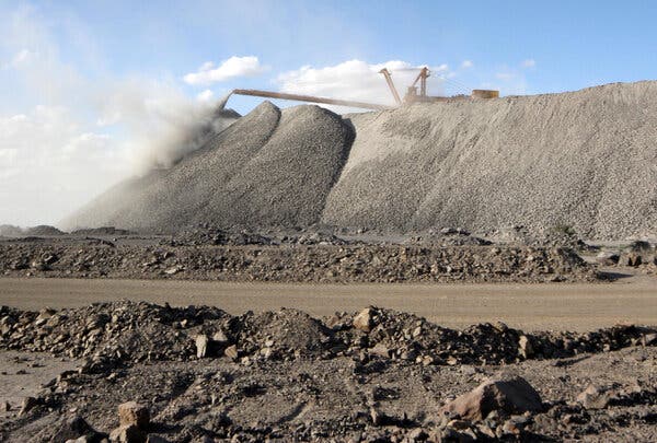 Mining machine sitting atop a large pile of earth.