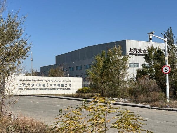 The exterior of a Volkswagen and SAIC assembly plant, surrounded by trees.