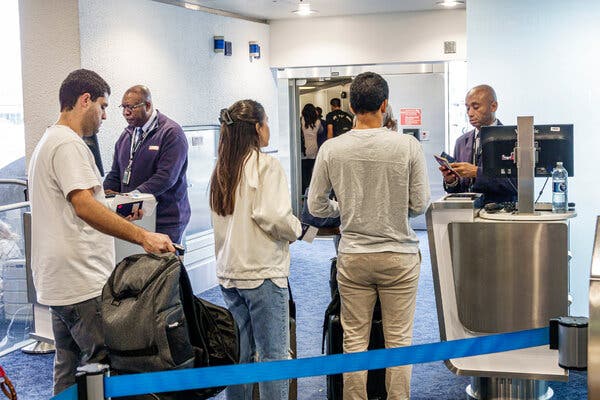 Passengers lining up at a gate to board a flight.