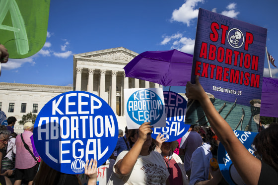 Abortion rights and anti-abortion  activists protest and hold signs