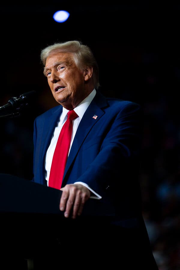 Donald Trump speaking into a microphone at a podium.