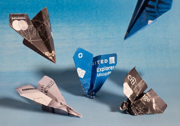 A photo illustration of credit cards folded into paper airplanes, crashing.