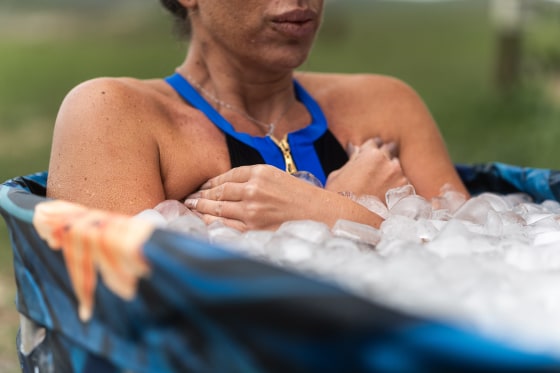 Female athlete taking ice bath for recovery after hard training session