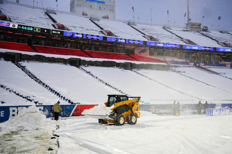 Snow clearing equipment clears the field of snow at an outdoor stadium