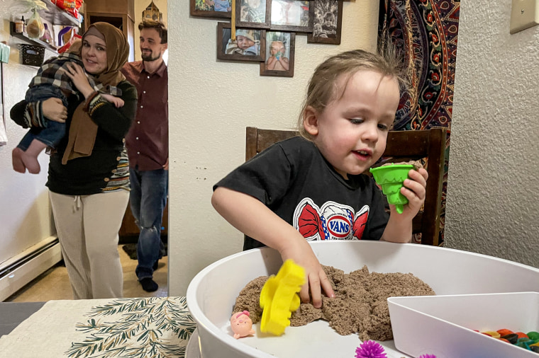 Jibreel Kassir plays with sensory toys, behind him Mother Desiree Wines, Father Yasser Kassir and baby brother Laith Kassir at home in Englewood, Colo.