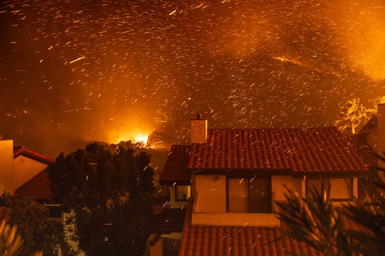 Embers fly through the air above rooftops