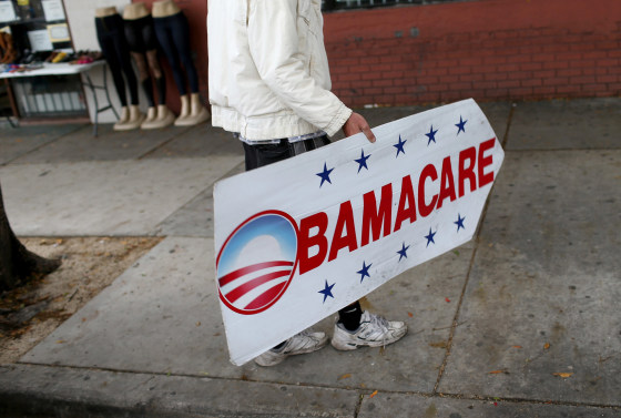 190327-obamacare-mc-828-540f32-1 Image: Pedro Rojas holds a sign directing people to an insurance company where they can sign up for the Affordable Care Act, also known as Obamacare