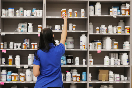 240626-pharmacy-prescription-drugs-se-1007a-192baf-1 A pharmacy technician grabs a bottle of drugs off a shelf at a pharmacy