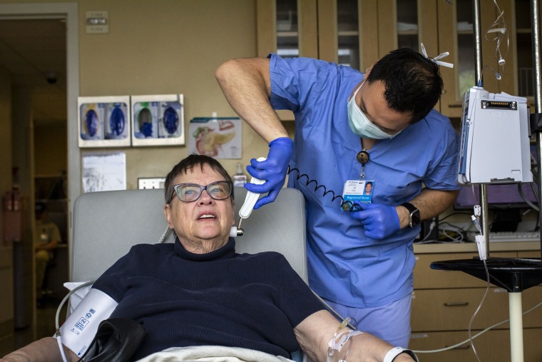 250411-harborview-medical-center-5-ew-611p-faa4be Jeff Chun, a nurse at Harborview Medical Center, monitors Andrea Gilbert’s vital signs. Gilbert said she’s bonded with fellow patients and health workers at Harborview Medical Center. “Everyone is very convivial, and you get snacks,” Gilbert said.