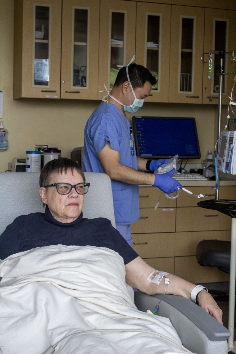 250411-harborview-medical-center-6-ew-611p-3beb6d Andrea Gilbert prepares to receive an infusion of lecanemab that is being prepared by registered nurse Jeff Chun. “It’s just something you have to face,” Gilbert said of her Alzheimer’s diagnosis. “Life goes on and it’s pretty good.”